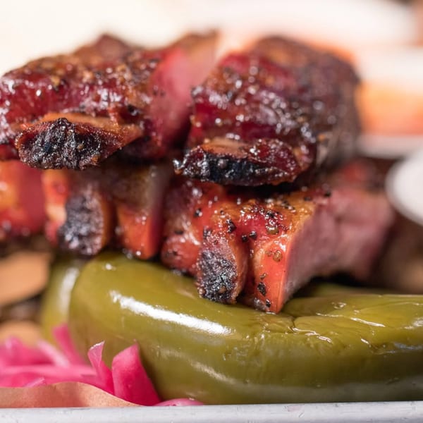 Close-up of The Cross-Eyed Cricket's BBQ ribs, pickled jalapeños, and red onions.